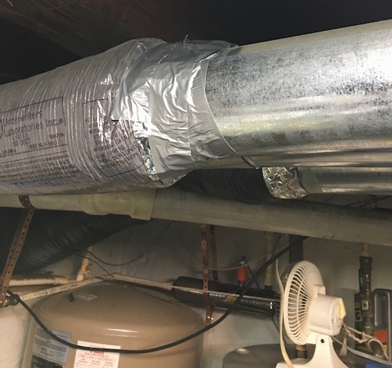 A basement in a home with fiberglass wrapped ducts with the fiberglass sealed with duct tape