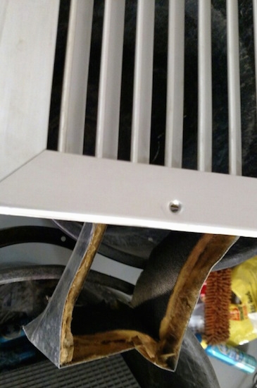 A white vent and a section of a fiberglass liner that was lining the vent