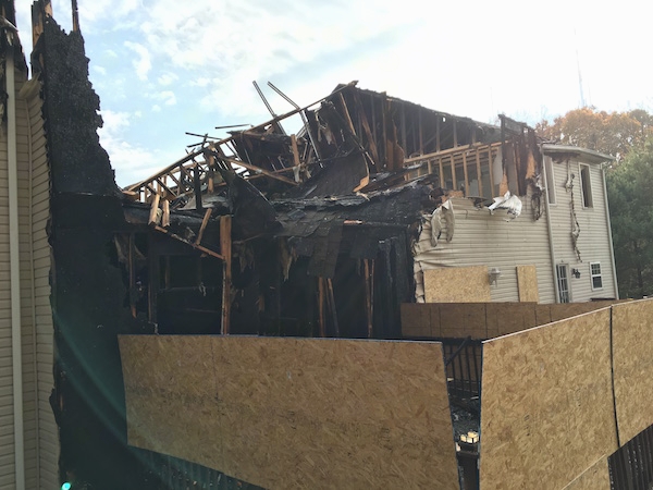 The backside of a tan townhome that burned down in a fire.