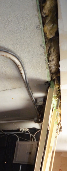 old insulation above a ceiling in a movie theater near the fuse box