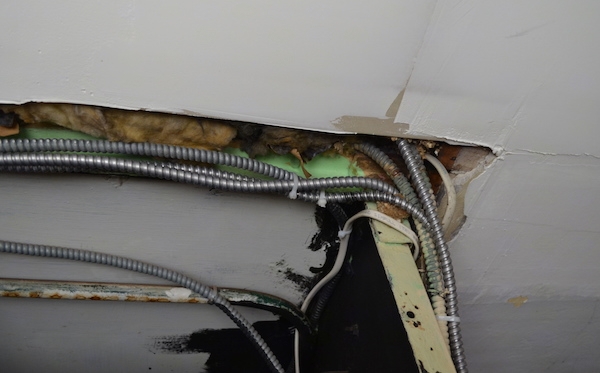 old insulation above a ceiling in a movie theater around the conduit wires