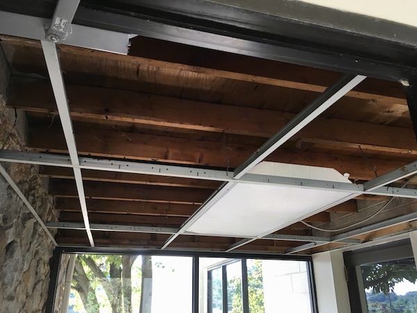 Inside of a vestibule with the ceiling panels removed where the fiberglass insulation was taken out.