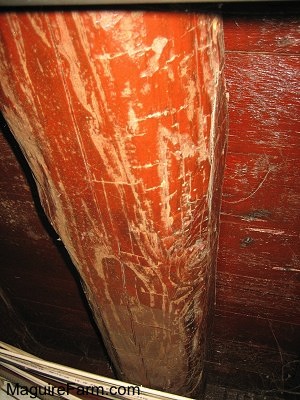 Close up - red colored old basement wooden beam with axe marks in the wood